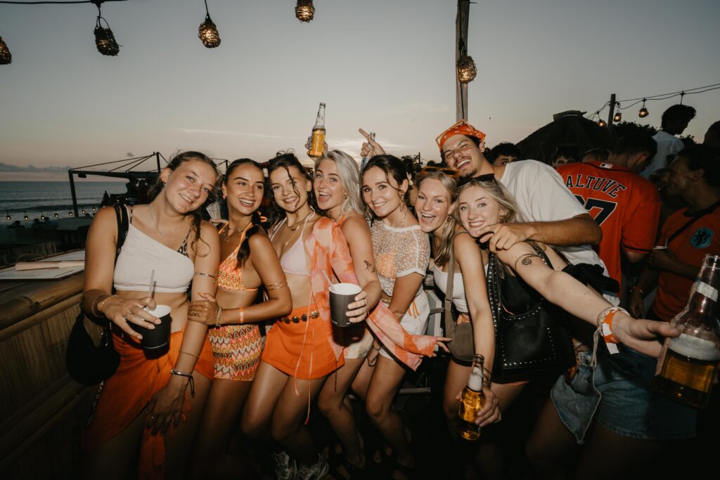 Group of friends celebrating Kingsday in Bali at Sol Rooftop Bali with drinks and sunset vibe